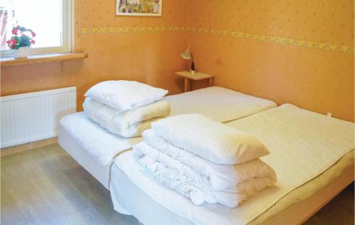 YngsjöにあるNice Home In Yngsj With 3 Bedroomsのベッドルーム1室(白いシーツと枕のベッド2台付)