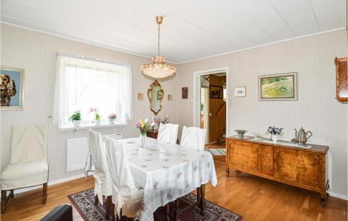 a dining room with a table and a chandelier at Cozy Home In Vänersborg With Wifi in Vänersborg