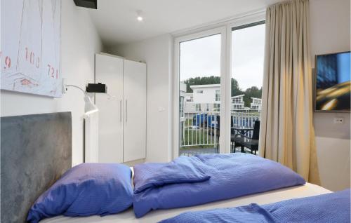 a bed with blue pillows in a room with a window at Dnenvilla Comfort in Travemünde