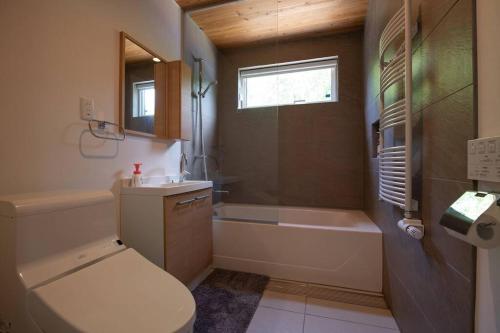 a bathroom with a toilet and a tub and a sink at Yuki no Taki 2 in Niseko