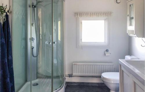 ein Bad mit einer Dusche, einem WC und einem Fenster in der Unterkunft Beautiful Home In Kristinehamn With 2 Bedrooms And Wifi in Kristinehamn