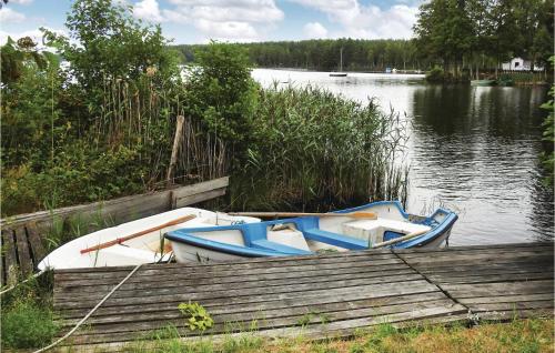 two boats are docked at a dock on a lake at Amazing Home In Fröseke With Sauna in Fröseke