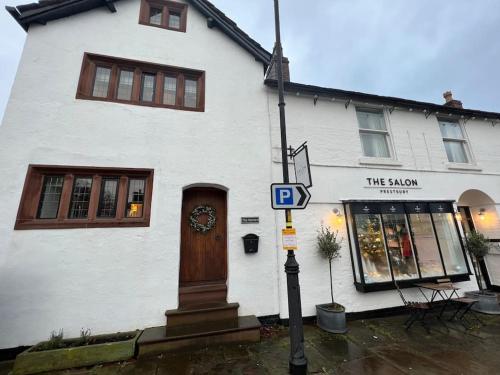 a street sign in front of a white building at The Horners - Log burner, Cheshire Village, Parking, Walks, Aga, dogs in Prestbury