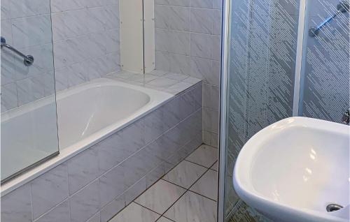 Baño blanco con bañera y lavamanos en 3 Bedroom Nice Home In Vlagtwedde, en Vlagtwedde