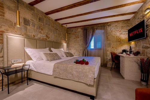 a bedroom with a large bed in a stone wall at Old Spalatrum Luxury Rooms in Split