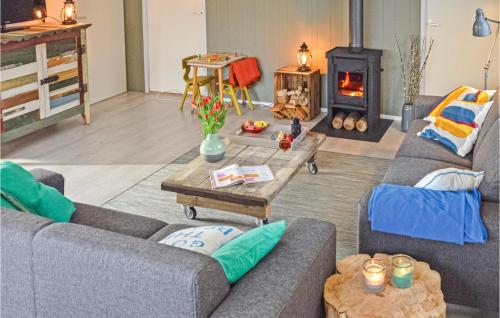 uma sala de estar com dois sofás e um fogão a lenha em Gorgeous Home In Julianadorp With Kitchen em Julianadorp