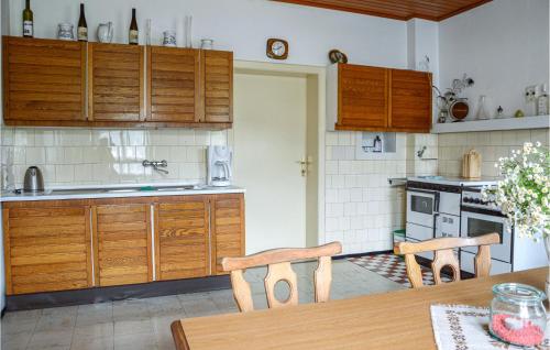 a kitchen with wooden cabinets and a table with chairs at Große Ferienwohnung Sierndorf in Sierndorf