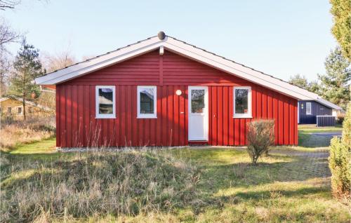 a red shed with a white door in a field at Frische Brise 22 - Dorf 3 in Priwall