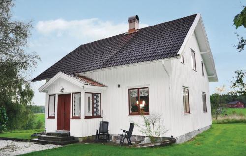 a white house with a black roof at Holiday Home Hedekas Lxii in Hedekas