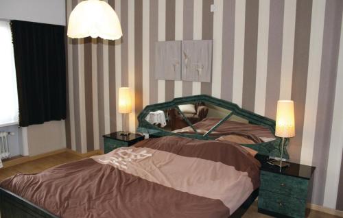 Nice Home In Ruiselede With Sauna في Ruiselede: غرفة نوم مع سرير مع مواقف ليلتين ومصباحين