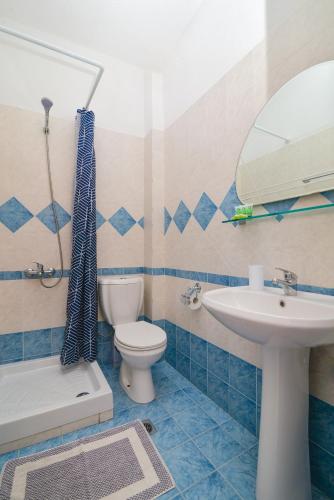 a bathroom with a toilet sink and a mirror at Hotel Fani in Leptokarya