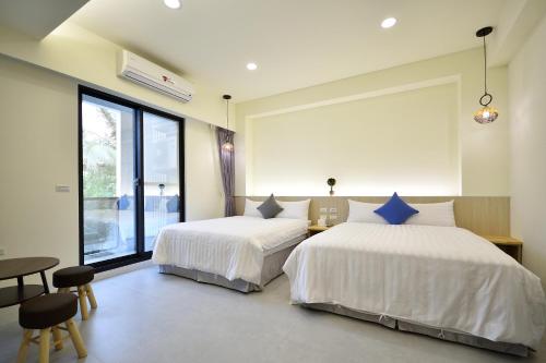 ein Schlafzimmer mit zwei Betten und einem großen Fenster in der Unterkunft 千晴包棟民宿 in Taitung