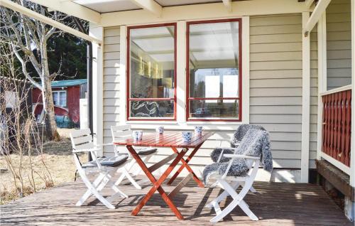 a table and two chairs on the porch of a house at Two-Bedroom Holiday Home In Ingaro in Grönskan