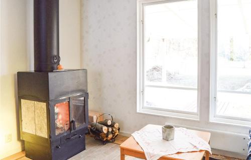 a fireplace in a living room with a window at Two-Bedroom Holiday Home In Ingaro in Grönskan