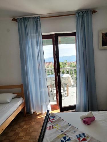 a bedroom with two beds and a large window at Sobe Apartma Galic in Novi Vinodolski