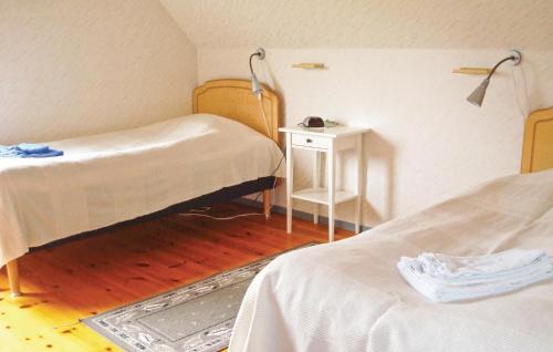 Habitación hospitalaria con 2 camas y mesa en 5 Bedroom Awesome Home In Strngns en Aspö