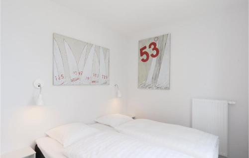 a white bedroom with a bed and a number on the wall at Promenadenvilla in Priwall