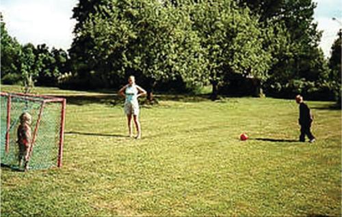 a woman and a man and a dog in a field at Awesome Home In Svärdsjö With Sauna in Vintjärn