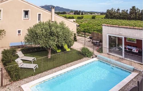 a swimming pool in a yard next to a house at 3 Bedroom Cozy Home In Violès in Violès