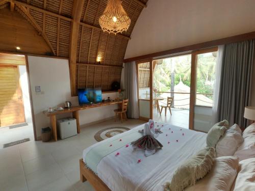 een slaapkamer met een groot wit bed in een kamer bij Coco Cabana in Gili Trawangan