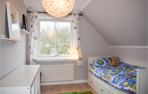 a childs bedroom with a bed and a window at Cozy Home In Vittaryd With Wifi in Vittaryd
