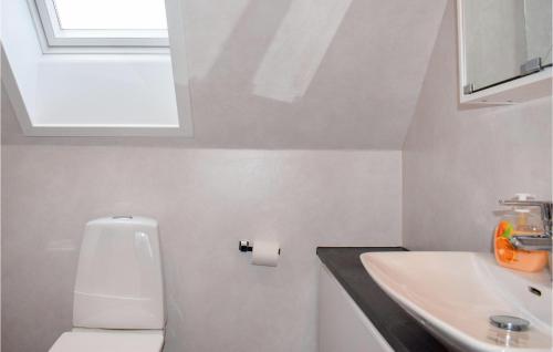 Baño blanco con aseo y lavamanos en Cozy Home In Vittaryd With Wifi, en Vittaryd