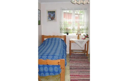 um quarto com uma cama e uma mesa com uma janela em Lovely Home In Lrbro With Kitchen em Kappelshamn