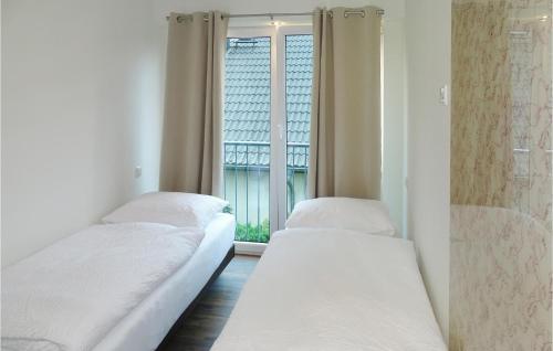 two beds in a room with a window at Haus 5 in Wendorf