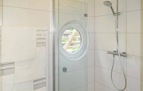 a bathroom with a shower with a round mirror at Haus 5 in Wendorf