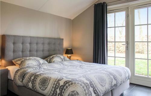 een slaapkamer met een groot bed en een groot raam bij Buitengoed Het Lageveld - 108 in Hoge-Hexel