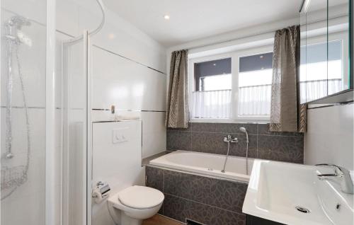 a bathroom with a toilet and a tub and a sink at Cozy Apartment In Rechlin With Sauna in Zielow