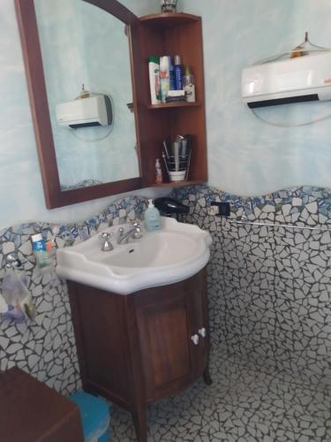La salle de bains est pourvue d'un lavabo et d'un miroir. dans l'établissement DOG HOUSE FROM POMPEI-AMALFI, à SantʼAntonio Abate
