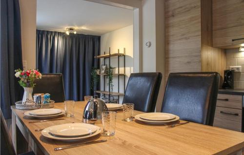 a wooden table with black chairs and a wooden table with plates at Oud Kempen Bungalow 173 in Stavenisse