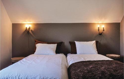two beds in a bedroom with two lights on the wall at Stunning Home In Leende With Wifi in Leende