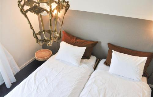 a bedroom with two beds with white sheets and a chandelier at Stunning Home In Leende With Wifi in Leende