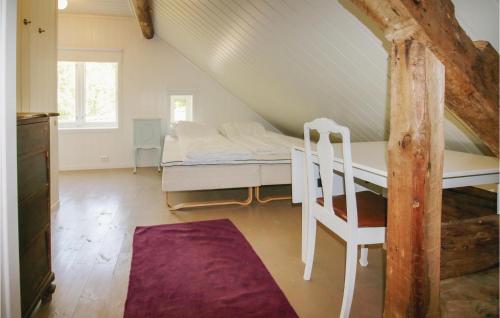 マンダールにあるStunning Home In Mandal With 5 Bedrooms And Wifiのベッドと椅子付きの屋根裏部屋