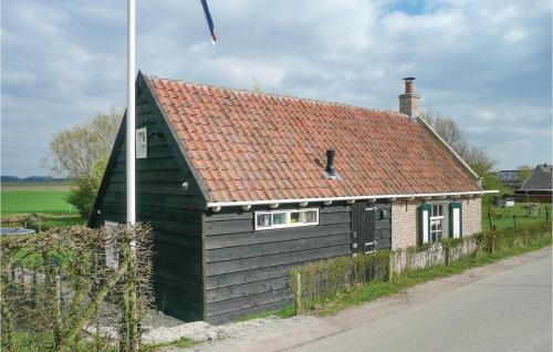 a small black house with a red roof at Het Kleinste Huisje in Maasdam