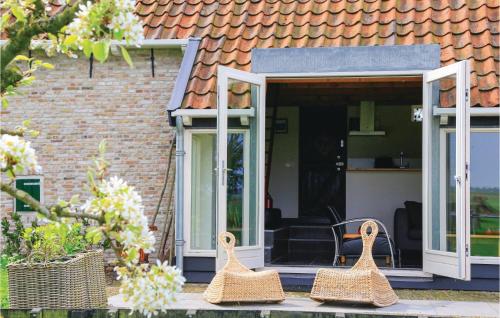 three wicker baskets sitting on the porch of a house at Het Kleinste Huisje in Maasdam