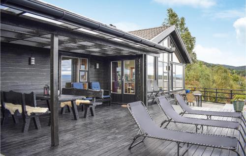 a deck with chairs and a table on a house at Nice Home In Nedstrand With Sauna in Nedstrand