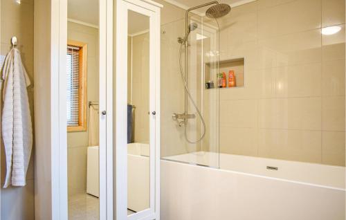 uma casa de banho com um chuveiro e uma banheira em Beautiful Home In Nedstrand With House Sea View em Nedstrand