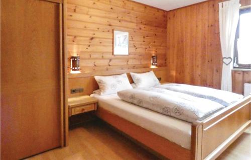 a bedroom with a bed with a wooden wall at Cozy Apartment In Grfendorf With House A Panoramic View in Gräfendorf
