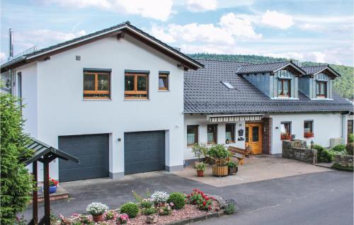 a white house with a garage at Nice Apartment In Gräfendorf in Gräfendorf
