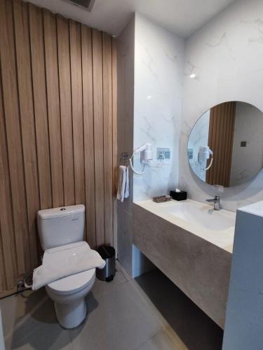 a bathroom with a toilet and a sink and a mirror at Raja Hotel Kuta Mandalika Resort & Convention in Kuta Lombok
