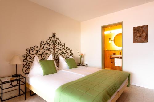 a bedroom with a large white bed with green accents at Boutique Hotel Sunstar Brissago am Lago Maggiore in Brissago