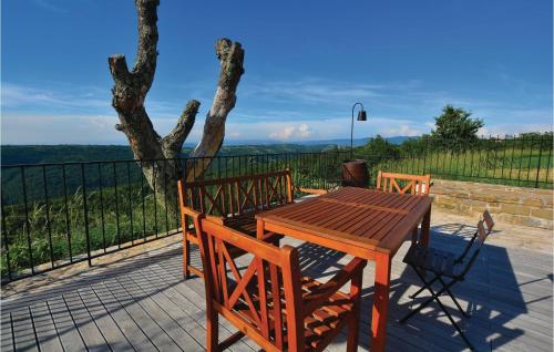 a wooden table and chairs on a patio with a tree at Lovely Home In Gracisce in Gračišče