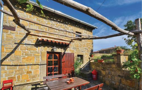 a stone house with a wooden table in front of it at Lovely Home In Gracisce in Gračišče