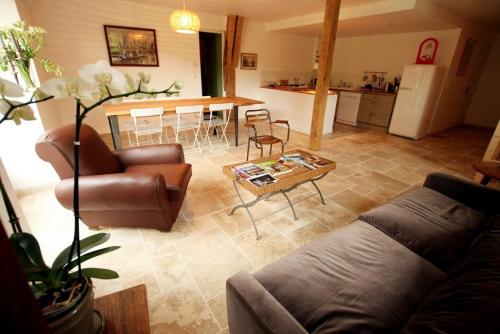 een woonkamer met een bank en een tafel bij Gite Le Rouvre in Cour-Cheverny