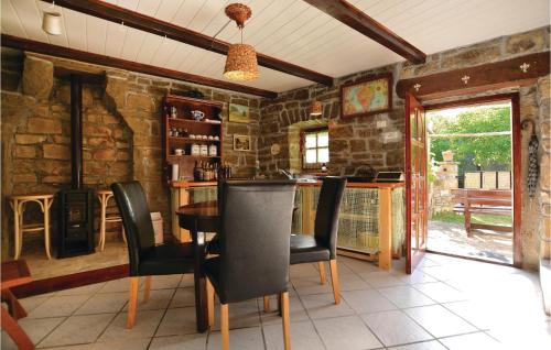 a dining room with a table and chairs and a stone wall at Lovely Home In Gracisce in Gračišče