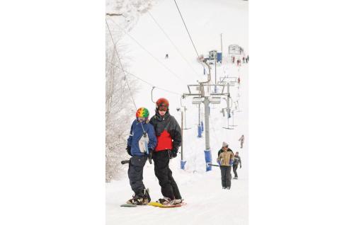 a man and woman standing on a ski lift at Pet Friendly Home In Tranås With Sauna in Tranås