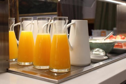 ラ・イグレスエラ・デル・シッドにあるHotel Palacio Matutano-Daudénのカウンターの上にオレンジジュースが入ったグラスが並んでいる